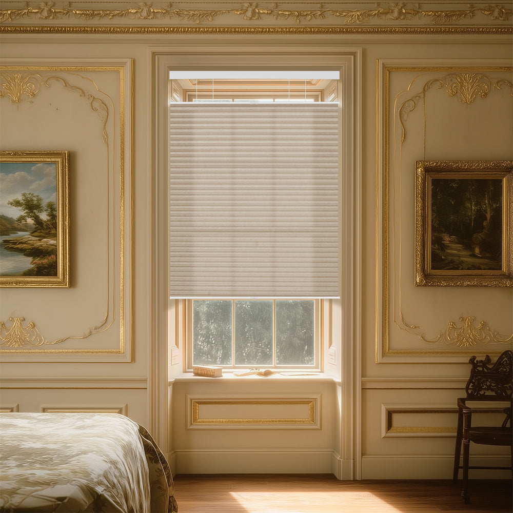 Elegant bedroom window with beige cellular shades, golden ornate wall moldings, landscape paintings