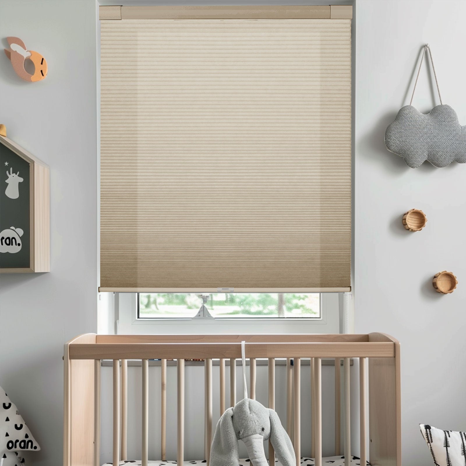 Modern nursery with beige window roller blind, wooden crib, and soft elephant toy