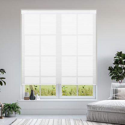White window roller blind in bright living room with green plants and gray sofa