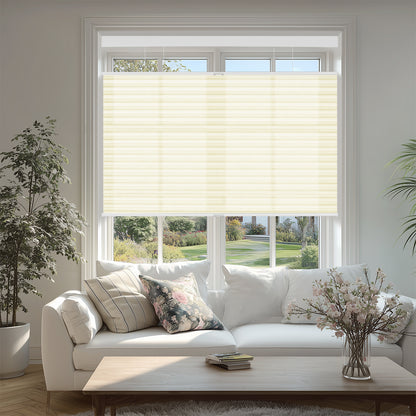 Bright living room with white sofa, floral and striped cushions, beige window blinds, and potted plants