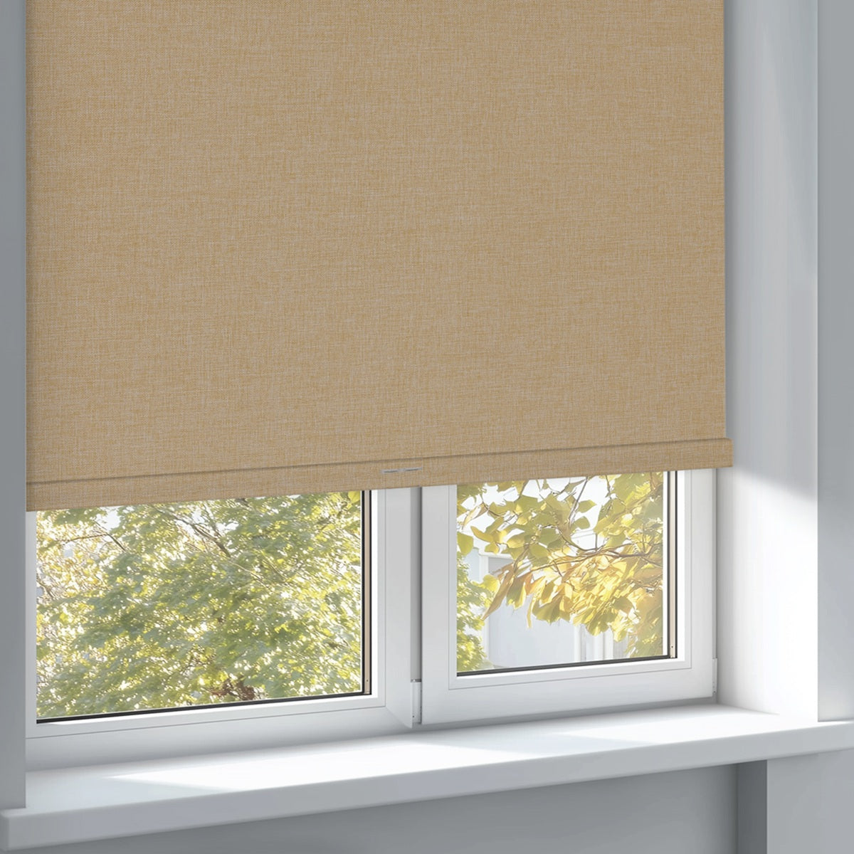 Beige fabric roller blind partially covering white-framed window with green tree view