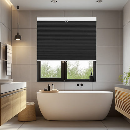 Modern bathroom with white freestanding tub, black roller blinds, wooden cabinets, and soft lighting