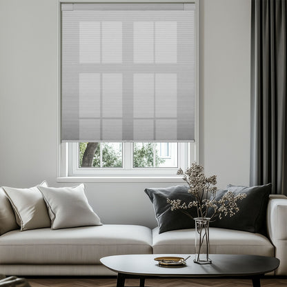 Modern living room with beige sofa, gray curtains, sheer blinds, and decorative vase on black coffee table