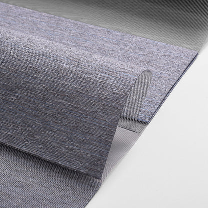 Close-up of blue-gray textured woven rug with folded edge on white background